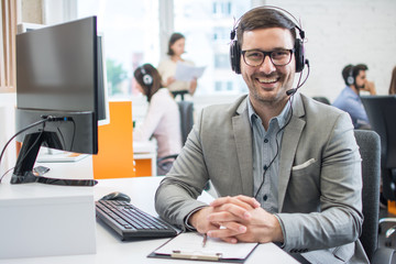 Customer service representative business man with headset in call center - obrazy, fototapety, plakaty