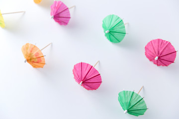 summer, accessory and decoration concept - cocktail umbrellas on white background