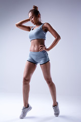 Fototapeta na wymiar The beauty lady in exercise suit is acting,show texture of fit and firm body