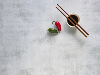 Fototapeta na wymiar Soy sauce with chopsticks and hot pepper on the table. Copy space.