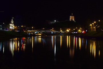 Night time cityscape of Vilnius with the street lights reflecting in water.