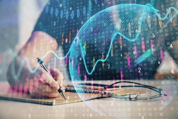 Multi exposure of woman's hands making notes with forex graph hologram. Concept of technical analysis.