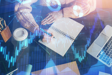 Forex graph on hand taking notes background. Concept of research. Double exposure