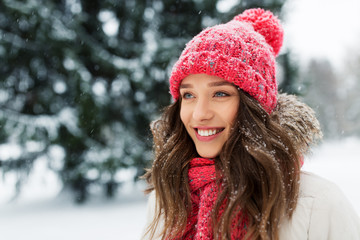 people, season and christmas concept - portrait of happy smiling teenage girl or young woman outdoors in winter park