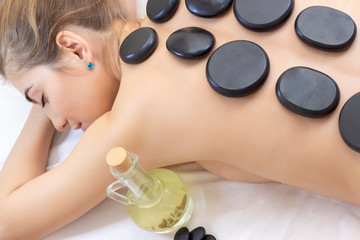 Obraz na płótnie Canvas Spa Hot Stone Massage. Stone treatment. Woman getting a hot stone massage at a day spa. beautiful girl