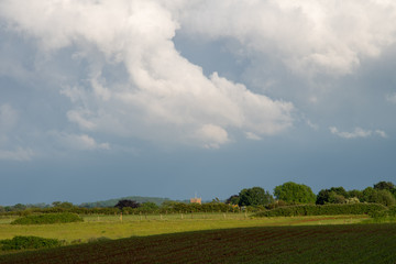 Storm clouds building over green fields and trees on a summer day in the countryside near Shenington, Oxfordshire