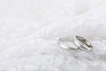 Silver rings on white lace fabric