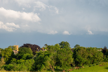 Storm clouds building over green fields and trees on a summer day in the countryside near Shenington, Oxfordshire
