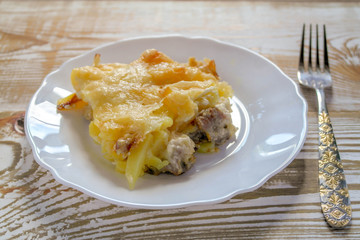 Ready meal - the Orlov-style meat with a piece cut off on a white plate. Freshly prepared dish with cut and close-up layers.