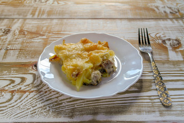 Ready meal - the Orlov-style meat with a piece cut off on a white plate. Freshly prepared dish with cut and close-up layers.