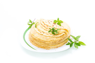 many fried thin pancakes in a plate, on white background.
