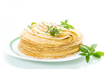 many fried thin pancakes in a plate, on white background.