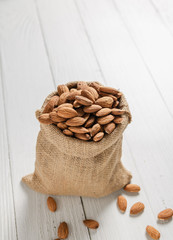 Almonds in hemp sacks Placed on a white wooden floor