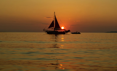 Sailing ship at sea at sunset