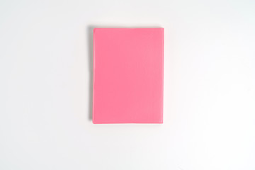Pink notebook on white desk. Business minimal concept for women. Flat lay, top view, copy space
