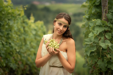 Young woman in tunic harvesting grapes