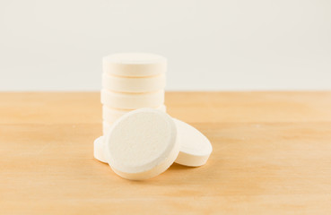 large round pills on wooden background