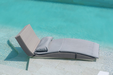 Relaxing or  Leisure rattan chair bed  in swimming pool with blue sky and cloud