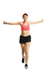 Fototapeta premium Young smiling woman in sportswear running and spreading arms