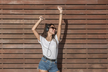 Energetic woman listening to music and dancing