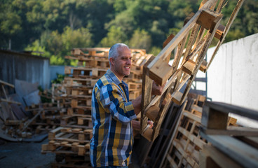 Obraz na płótnie Canvas a carpenter repairs wooden pallets