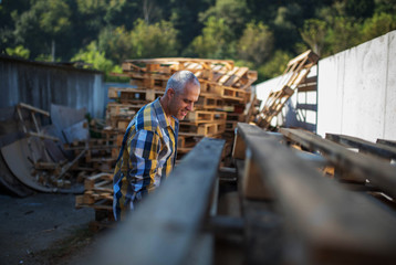 a carpenter repairs wooden pallets