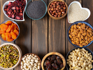 nuts, seeds and dried fruis on wooden surface