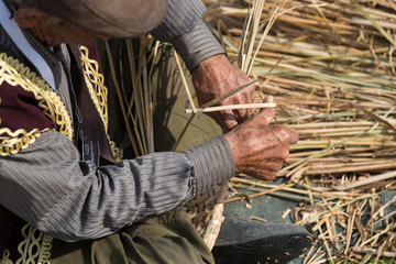 the man has veteran hands make basket with wicker.