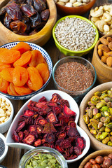 nuts, seeds and dried fruis on wooden surface