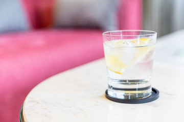 Water and lemon pour into a glass.