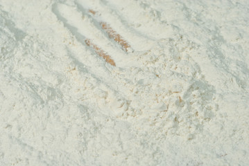 Texture of wheat flour. White flour closeup. Traces from the toes of the croup.