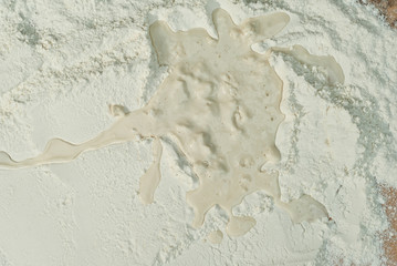Texture of wheat flour. White flour closeup. Drop of water on cereals. Flour diluted with water.