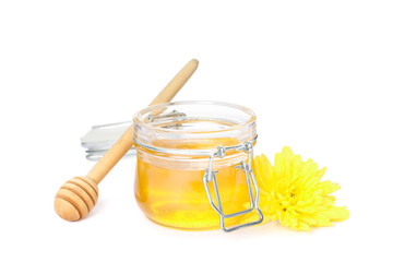 Dipper, chrysanthemum and glass jar with honey isolated on white background