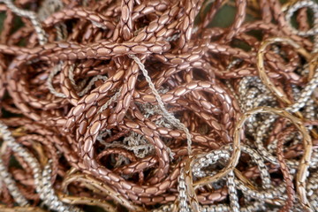 Jumble of many necklaces and bracelets made of copper and silver. Background, Texture, Close-up