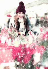 Girl buying floral compositions at Christmas market