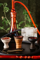  We hammer different bowls and hookahs for guests. in the background are different types of hookahs and cups.