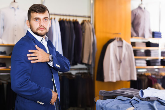 Positive male customer choosing jacket