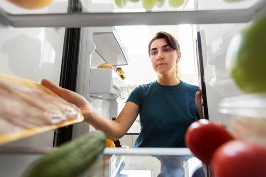 Healthy Eating, Food And Diet Concept - Woman Taking Meat From Fridge At Home Kitchen