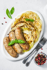 Grilled cabbage steaks with smoked sausages.Top view, copy space.