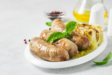 Garlic roasted cabbage steaks with spicy sausages. Selective focus, copy space.