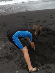 girl with neoprene playing in the beach