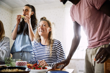 Low angle view of happy friends enjoying food in social gathering at home