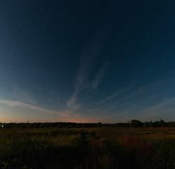 Fototapeta na wymiar Starry sky over the road in the field