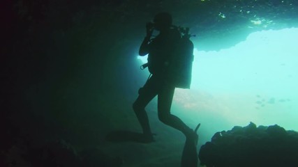 Large cave underwater with divers