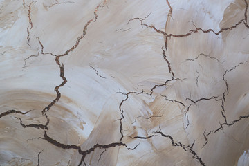 Fototapeta premium texture of beige wall with golden cracks. Decorative plaster background for walls and interior. close-up