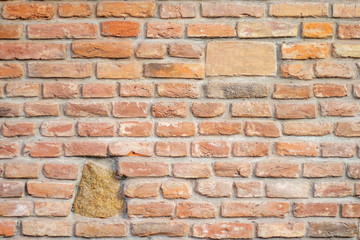Red clay brick mixed with stones wall old texture. One bigger than other bricks for text and copyspace. Vintage interior brickwork backdrop. Red brown stonewall surface. Grunge horizontal background.