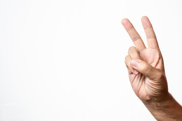 Caucasian male adult hand showing victory or peace gesture in studio shot isolated on white background