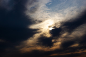 The sun is hidden behind black clouds.