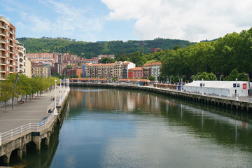 Fototapeta na wymiar Exterior baroque architecture in Bilbao in Basque country. View from Arenal Bridge over river Nervion / Nerbioi. Lifestyles of the capital in summer sunny day.