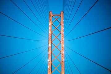 pylons of the cable-stayed suspension bridge with ropes against the background of the evening dark blue sky